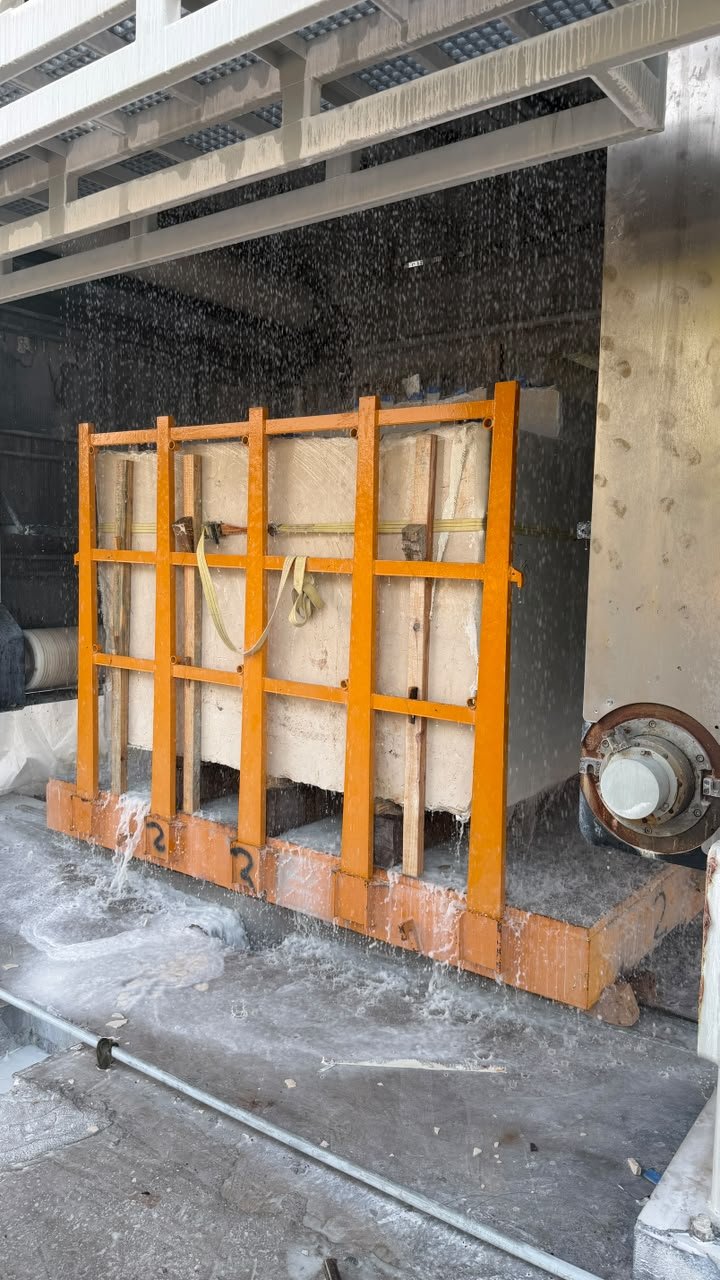 Italian marble slabs being processed under water spray